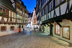 People walk in Petit France district of Strasbourg at dusk by Marco Brivio