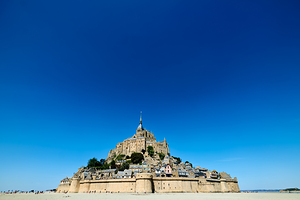 Mont Saint Michel rises above the ground during low tide in Norm by Marco Brivio