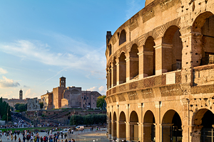 Colosseum stands in Rome with visitors exploring nearby by Marco Brivio