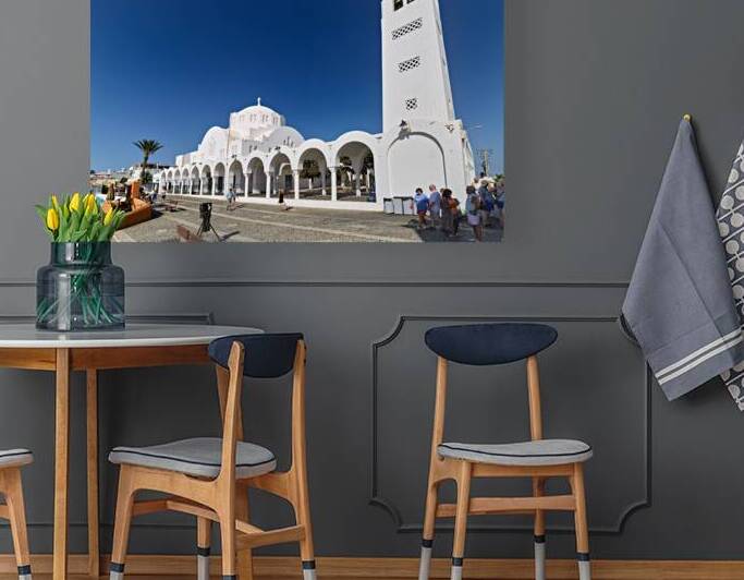 Iconic white church in Santorini under a bright blue sky. by Marco Brivio