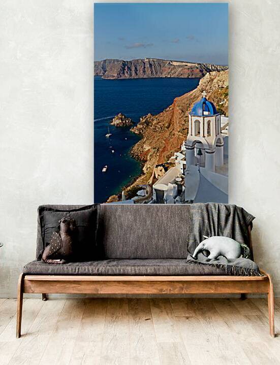 Santorinis iconic blue domed church overlooks the caldera and v by Marco Brivio