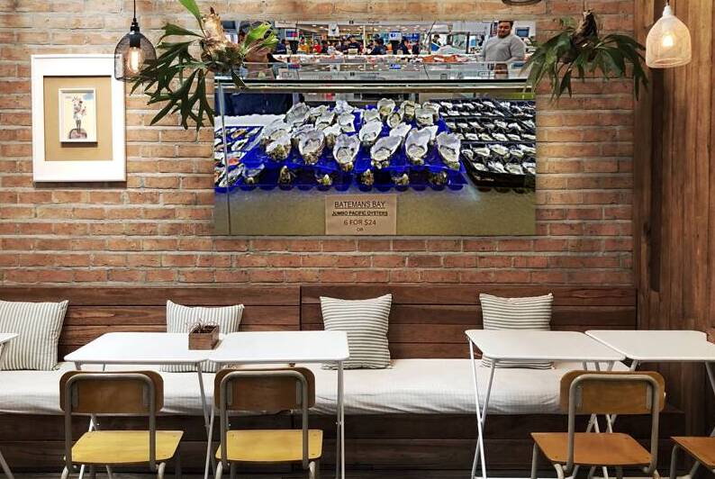 Fresh oysters on display at a seafood market. by Marco Brivio