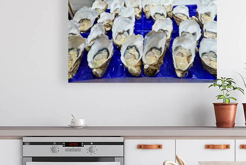 Freshly shucked oysters on ice at a market stall. by Marco Brivio