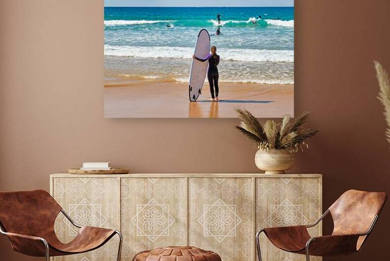 Surfer girl with surfboard on beach watching waves by Marco Brivio