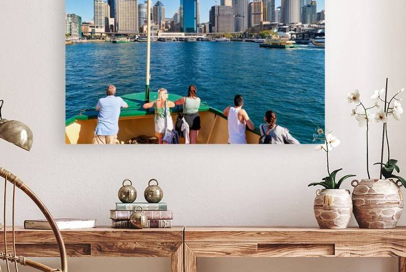 People on ferry enjoy view of Sydney skyline and harbor. by Marco Brivio