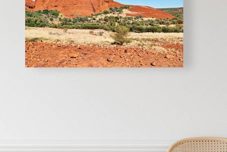 Vast red rock formation under a clear blue sky. by Marco Brivio