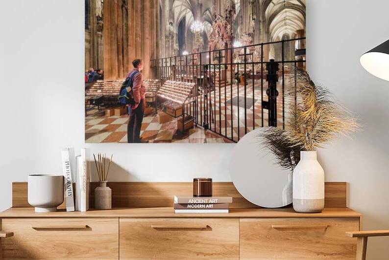 Man observes prayer candles in a grand cathedral. by Marco Brivio