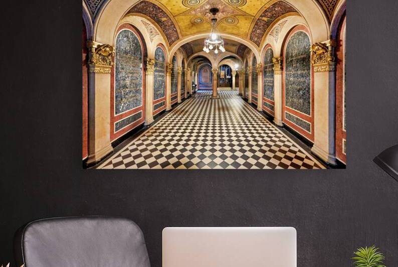 Historic church corridor with ornate arches and checkered floor. by Marco Brivio