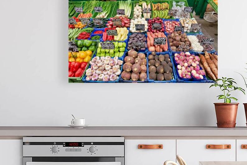 Colorful fresh vegetables and fruits displayed at a market stall by Marco Brivio