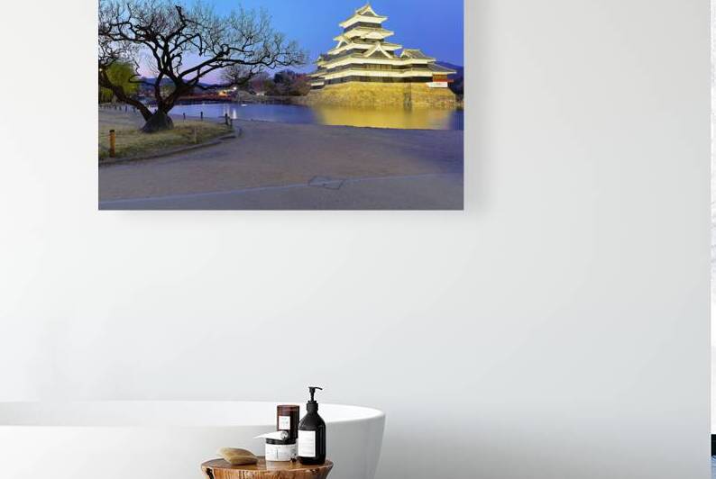 Matsumoto Castle stands by a river at sunset in Japan by Marco Brivio