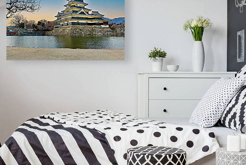 Matsumoto Castle standing by water during sunset in Japan by Marco Brivio