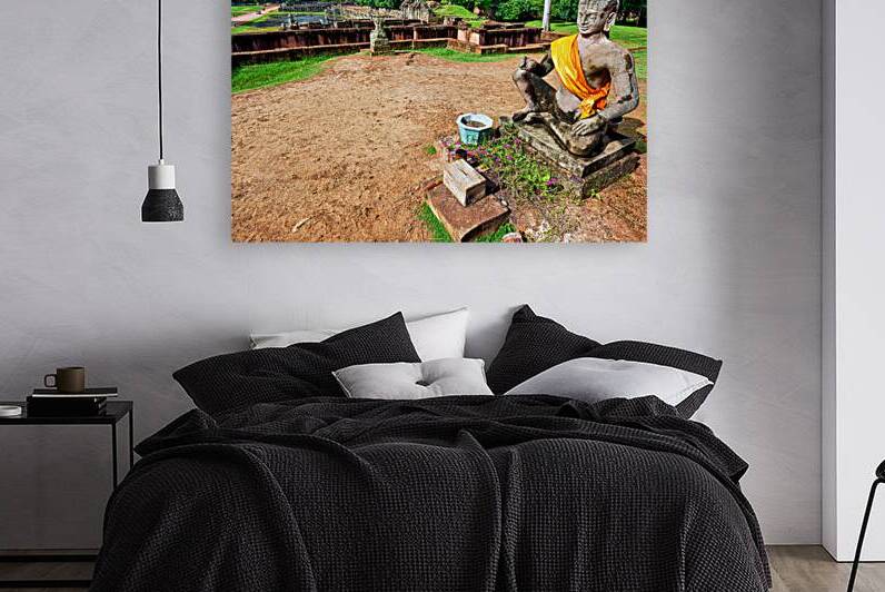 Ancient statue overlooks temple ruins amidst lush greenery. by Marco Brivio