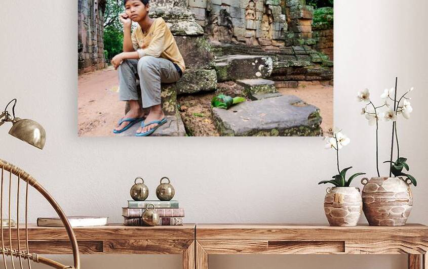 Young person sits on ancient temple ruins. by Marco Brivio