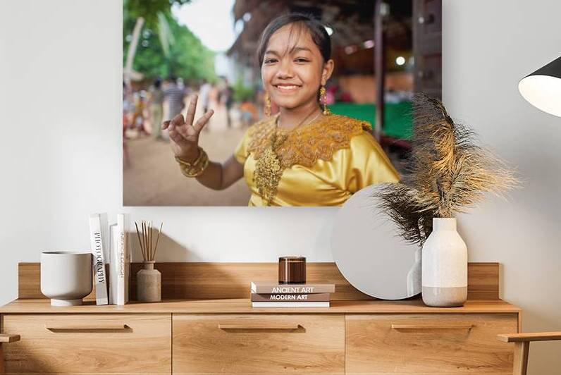 Smiling girl in golden traditional dress makes peace sign. by Marco Brivio