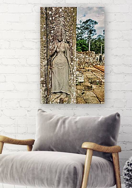 Ancient Apsara carving on weathered temple wall. by Marco Brivio