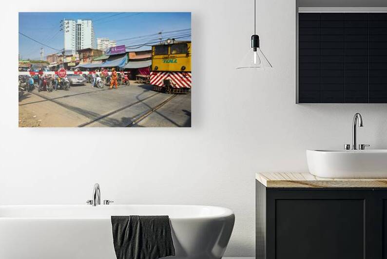 Train crossing busy street with motorbikes and people. by Marco Brivio