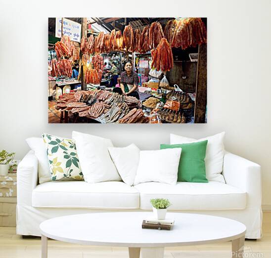 Woman sells dried fish at a bustling Cambodian market. by Marco Brivio