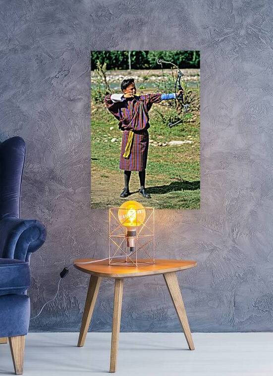 Bhutanese archer in traditional Gho aiming a compound bow. by Marco Brivio