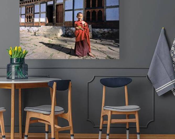 Young monk with toy gun and bread outside a monastery. by Marco Brivio