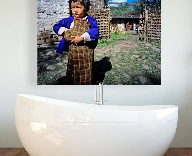 Young child in traditional Bhutanese dress in village. by Marco Brivio