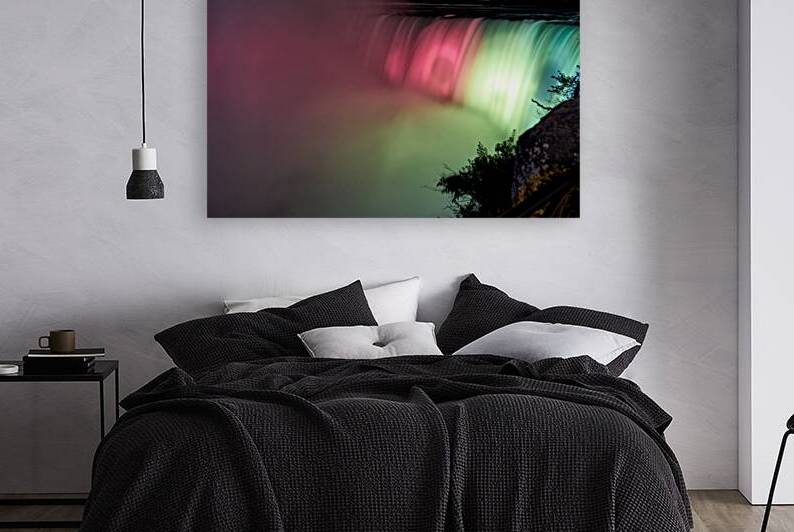 Niagara Falls illuminated at night with colorful lights. by Marco Brivio