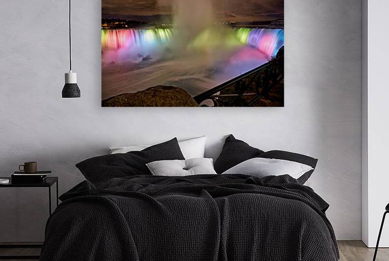 Niagara Falls illuminated at night with colorful lights. by Marco Brivio