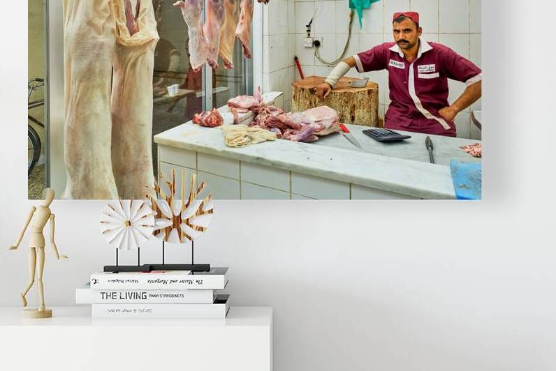 Butcher works in meat market in Dubai with hanging meat by Marco Brivio