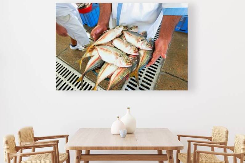 Freshly caught fish in Dubai held by a man at the market by Marco Brivio
