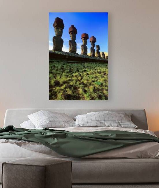 Row of Moai statues with red hats on Easter Island. by Marco Brivio