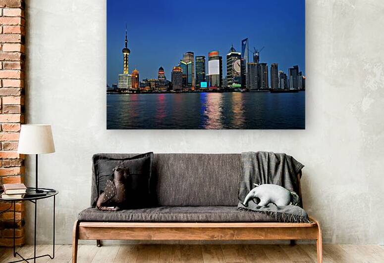 Shanghai skyline lights up at night over the river by Marco Brivio