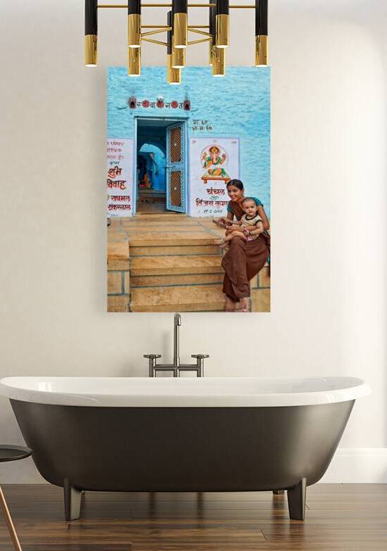 Mother and son sit on steps near a blue building in Jaisalmer by Marco Brivio