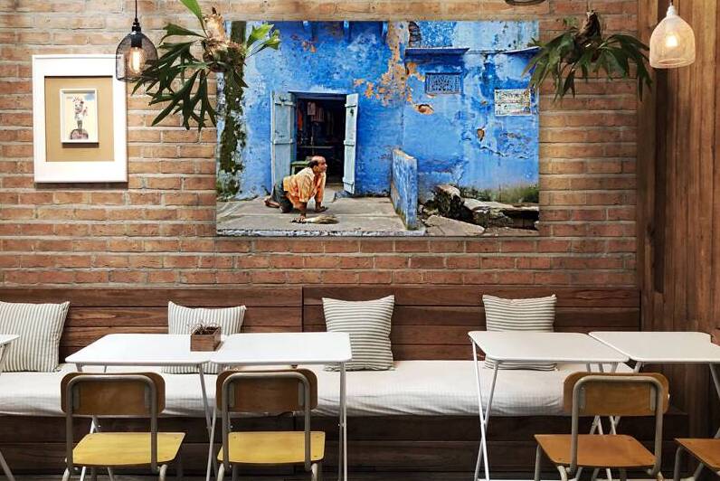 Man sweeps in front of home in Bundi Rajasthan during the day by Marco Brivio