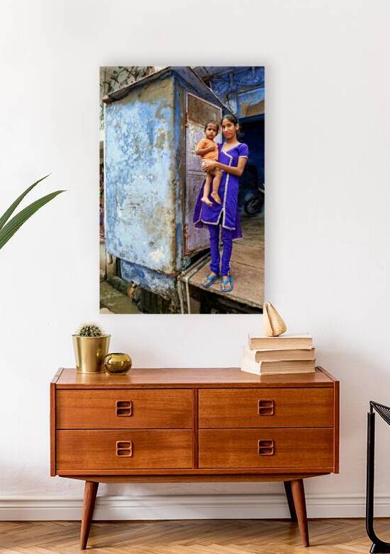 Mother holds son near blue building in Bundi Rajasthan by Marco Brivio
