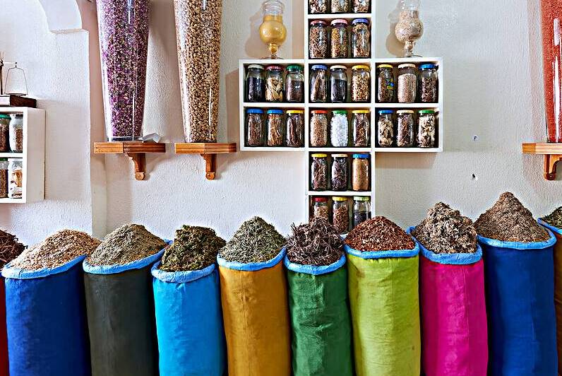 Herbal remedy shop in Marrakesh showing colorful bags of herbs by Marco Brivio