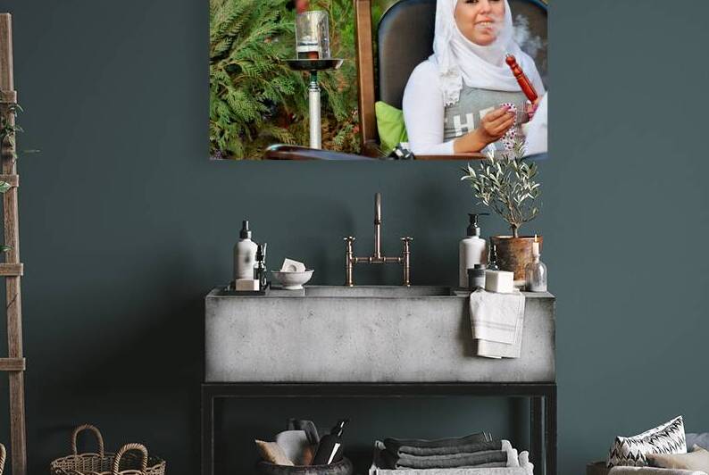 Young woman smokes hookah in outdoor cafe in Aleppo Syria by Marco Brivio