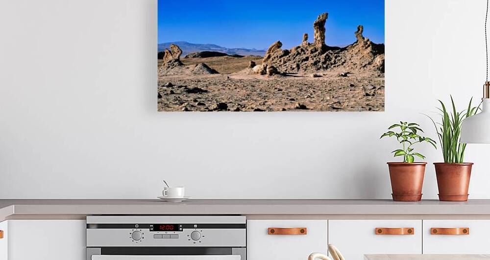 Arid desert with unusual rock pillars against a blue sky. by Marco Brivio