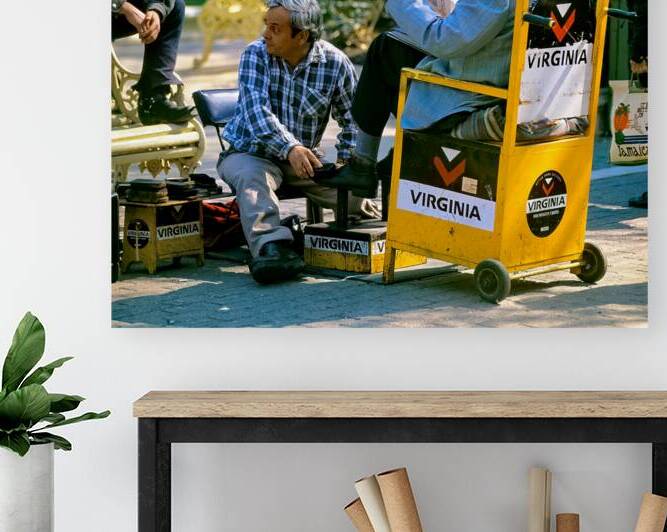 Shoeshine man works while customer reads newspaper. by Marco Brivio