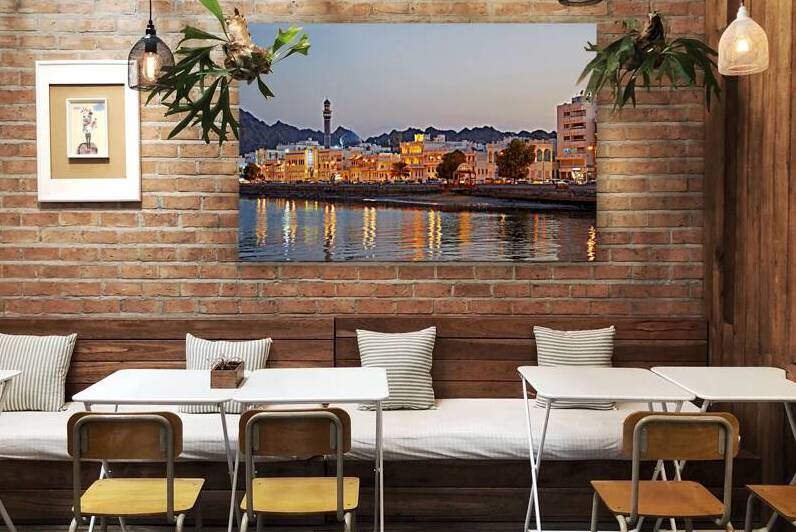 Sunset view of waterfront in Muscat Oman with city lights by Marco Brivio