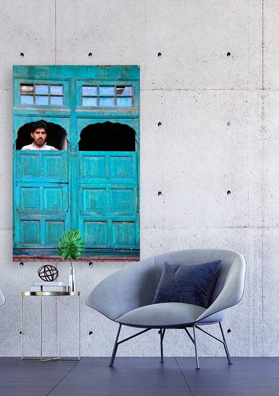Man looks out from window in Lahore Pakistan by Marco Brivio