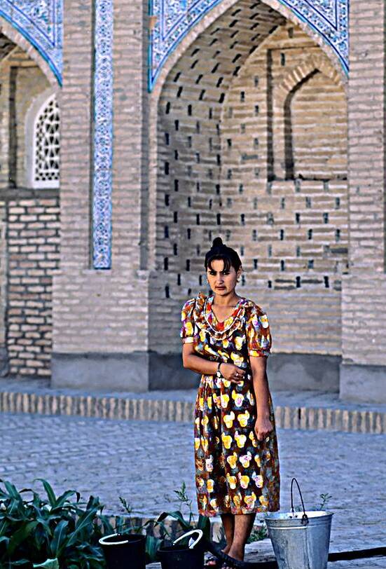 Woman standing in Khiva Uzbekistan near a historical building by Marco Brivio