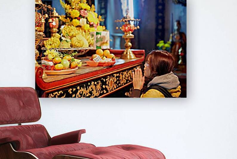 Person offers prayers at altar with fruits in Ho Chi Minh by Marco Brivio