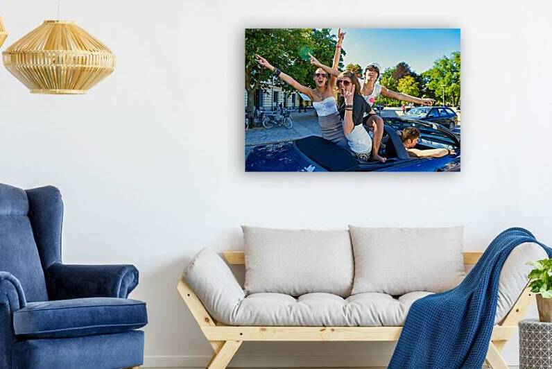Young women enjoy a fun time on a car in Stockholm by Marco Brivio